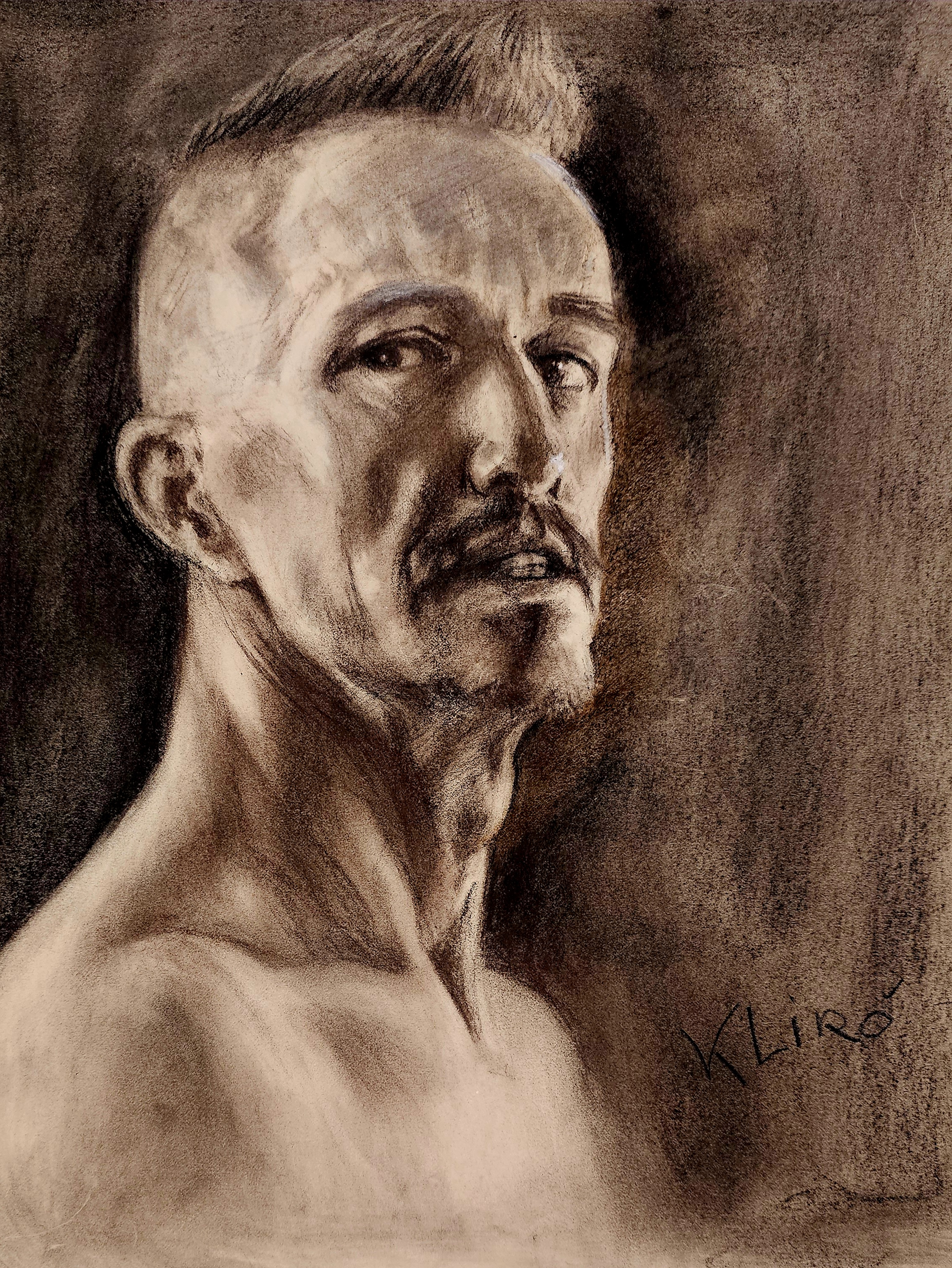 Ritratto a carboncino di volto d'uomo eseguito da Klirò